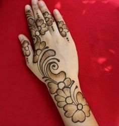 a woman's hand with henna tattoos on it