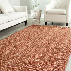 an orange area rug is on the floor in front of a white couch and chair