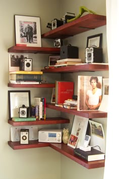 the shelves are filled with books, pictures and cameras