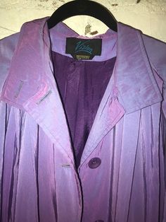 This vintage Vision jacket is a stunning metallic purple trench coat, perfect for any occasion. The long-sleeved coat features a button closure, shoulder pads, and pockets, and is made from embossed synthetic fabric with a synthetic lining. The coat is a size M and should be dry cleaned only. This colorful jacket is perfect for those who love 80s fashion, anime, and metallic accents. The coat has a bladerunner vibe and is sure to make a statement wherever it is worn. The jacket is a regular size and has a collar, while the garb care is dry clean only. With its unique features, this vintage coat is a must-have for any fashion lover. Retro Purple Outerwear For Winter, Purple Coat Aesthetic, Metallic Purple Coat, Dark Purple Trench Coat, Purple Trench Coat, Streetwear Coat, Vintage Purple Cotton Outerwear, Colorful Jacket, 80s Women