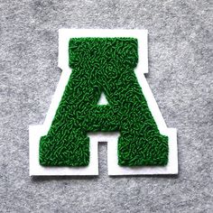 the letters are made out of grass and placed on top of each other in front of a gray background