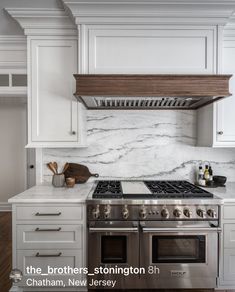 a stove top oven sitting inside of a kitchen next to white cabinets and counter tops