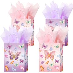 three bags with butterflies on them are sitting side by side, one is pink and the other is purple