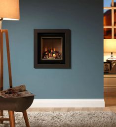 a living room with blue walls and a fire place in the corner that is lit