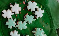 decorated cookies on a green plate with sprinkles