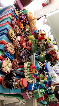 there are many different items on the table for sale in this market place, including hats and scarves