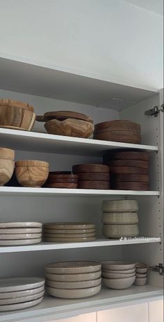 the shelves are filled with bowls and plates