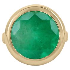 An exquisite Colombian emerald solitaire cocktail ring. Inspired by elaborate contemporary art, this piece shows how elegant simple can be. A large 11.33-carat, earth mined, round Colombian emerald sits delicately in a secure golden bezel. A rare beauty in every aspect. Unlike diamonds, a round-shaped emerald is characterized among the rarest cut for these precious gemstones, no less than an 11ct+ size. Gorgeous vivid green color with good eye clarity for its large size. Minor imperfections are normal for earth-mined gems and add to their unique ambiance. Designed and handcrafted in the best quality gold by our own master jeweler, Robinson. The shank of the ring is dexterously hand-crafted into a comfort band, making it a delight to wear. Setting Style: Bezel - Solitaire Setting Material: Colombian Emerald Ring, Statement Engagement Ring, Emerald Gem, Solitaire Setting, Hand Ring, Colombian Emeralds, Clear Stone, Emerald Pendant, Yellow Gold Setting