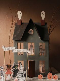 a house with halloween decorations on the front and side, along with two ghost figurines