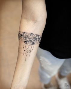 a woman's arm with a tattoo on it that has an intricate design and beads