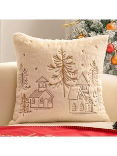 a christmas tree pillow sitting on top of a white couch next to a christmas tree