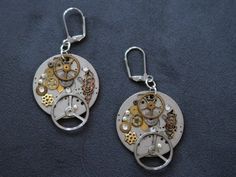 "These steampunk style earrings are made from the movements of vintage men's watches from the 1950's. I have added gold and silver wheels from pocket watches to make the earrings more interesting. The wheels are older than the movement probable from the 1930's or 1940's. I also added Austrian crystals and they were new. Birthstones can be added to personalize the earrings. Please contact the artist for this request. They are approximately almost 1\" in diameter with surgical steel lever back ear Steampunk Ideas, Gold Wheels, 1950s Mens, Steampunk Earrings, Round Earring, Steam Punk Jewelry, Small Watch, Style Steampunk, Bronze Jewelry