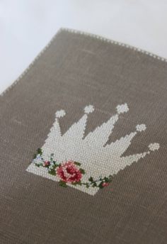 a close up of a piece of cloth with a flower on it and a crown