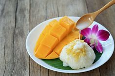 a white plate topped with different types of food and a wooden spoon on top of it