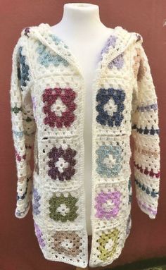 a white crocheted jacket with multicolored flowers on the front and sides