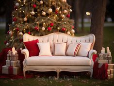 a white couch sitting next to a christmas tree with red and white pillows on it