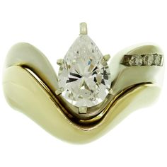 an engagement ring with a pear shaped diamond in the center and two diamonds on each side