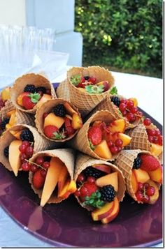 a plate filled with fruit and cones on top of a wooden table