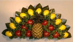 a bunch of fruits and vegetables arranged in the shape of a pineapple on a wall