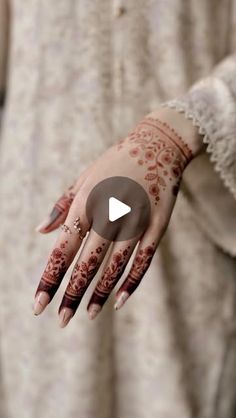 a woman's hand with henna tattoos on it