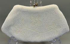 "This is a very collectible, Richere Brand, ivory-white beaded clutch.  This elegant hand beaded clutch was Made in Japan, in the 1950's.  The beading is excellent and has a simply elegant and understated floral design on front.  The backside has concentric rows of the tiny white-ivory beads.  The elegant clutch-handbag has a gold clasp with two big, brilliant rhinestones on the clasp, giving this bag another element of elegance.  The silky white fabric interior is in excellent condition with mi Vintage White Clutch For Party, Vintage White Clutch Evening Bag, Vintage White Beaded Clutch, White Rectangular Vintage Clutch, Elegant White Evening Bag For Vintage Events, White Beaded Evening Clutch, Vintage Cream Clutch For Events, Vintage White Clutch For Events, Vintage White Evening Bag For Events