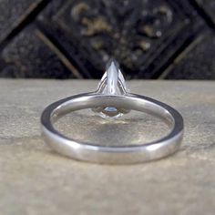 a diamond ring sitting on top of a stone slab