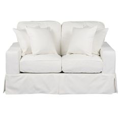 a white couch with two pillows on it's back and one arm folded down