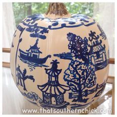 a large blue and white vase sitting on top of a table next to a window