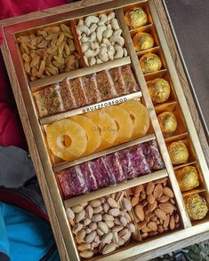 a wooden box filled with lots of different types of nuts and other food items next to each other