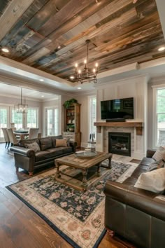 a living room filled with furniture and a flat screen tv mounted on the wall above a fireplace