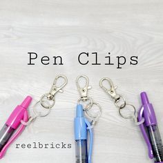 four pen clips sitting next to each other on top of a white surface with the words reebricks written below them