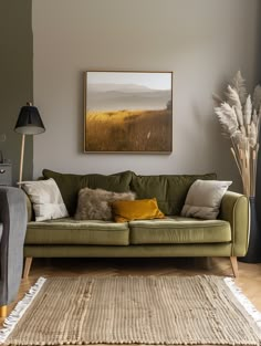 a living room filled with furniture and a painting hanging on the wall above it's headboard