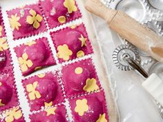 some pink and yellow pastries on a table next to other baking utensils