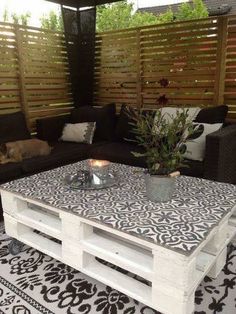 a white coffee table sitting on top of a black and white rug next to a couch