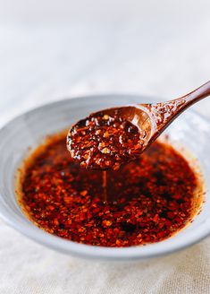 a spoon full of sauce on top of a white plate