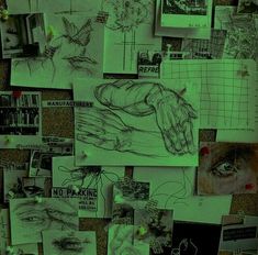 there are many drawings on the wall with green light coming from them and one person's hand holding something