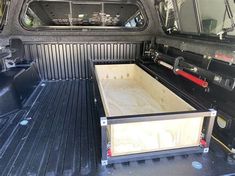 the back end of a black pickup truck with its bed open and two empty boxes in the trunk