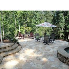 a patio with chairs and an umbrella over it