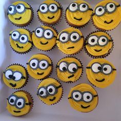 cupcakes with yellow frosting and eyes are arranged in a box on a table