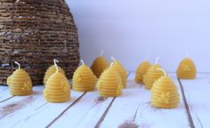 small bees are lined up next to each other on a wooden table with a wicker basket in the background