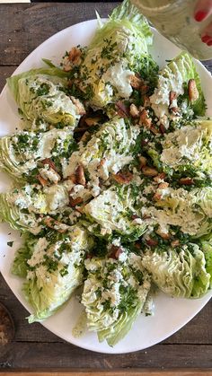 a white plate topped with lettuce covered in dressing