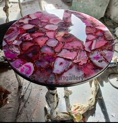 a table that has some kind of glass on it with red and pink paint all over it