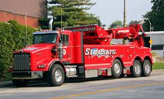 a large red truck parked on the side of a road