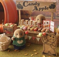 an assortment of candy apples displayed in front of a wooden sign that says candy apple