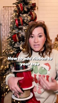 a woman holding a christmas present in front of a decorated tree with the words how to add ribbon to your tree