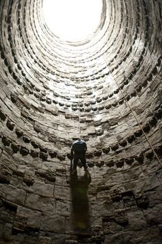 a man standing in the middle of a tunnel with words above it that read, why do we fall bridge? so we can learn to pick ourselves up