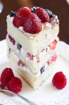 a piece of cake on a plate with raspberries