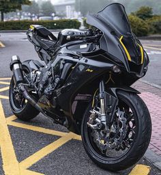 a black motorcycle parked in a parking lot next to a yellow line on the street