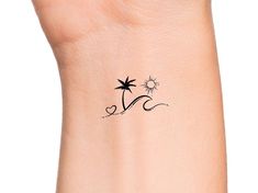 a small palm tree tattoo on the left side of the wrist is shown in black ink