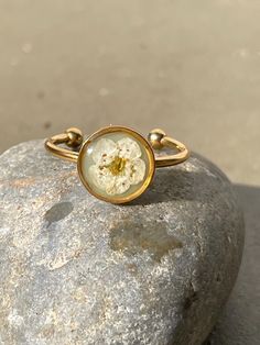 Dainty but stunning! Adjustable and stackable resin ring with white flower atop a garden green color resin background  8mm gold finish bezel Stainless steel adjustable ring Adjustable Gold Flower Ring Nature-inspired, Adjustable Gold Flower Ring, Nature-inspired, Gold Ring With Pressed Flowers, Dainty Flower Ring For Spring, Minimalist White Adjustable Flower Ring, Adjustable White Nature-inspired Rings, Adjustable Rings With Pressed Flowers, Delicate Adjustable Flower Ring, Adjustable Rose Gold Flower Ring